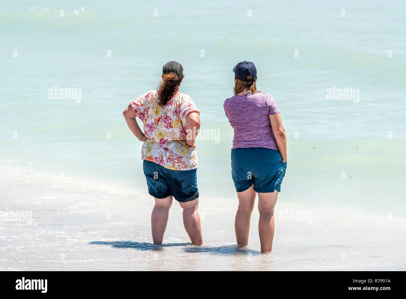 Sanibel Island, Stati Uniti d'America - 29 Aprile 2018: Bowman Beach, Florida con indietro di due donne in piedi sulla riva in acque turchesi sulla giornata di sole Foto Stock Sanibel Island, Stati Uniti d'America - 29 Aprile 2018: Bowman Beach, Florida con indietro di due donne in piedi sulla riva in acque turchesi sulla giornata di sole Foto Stock