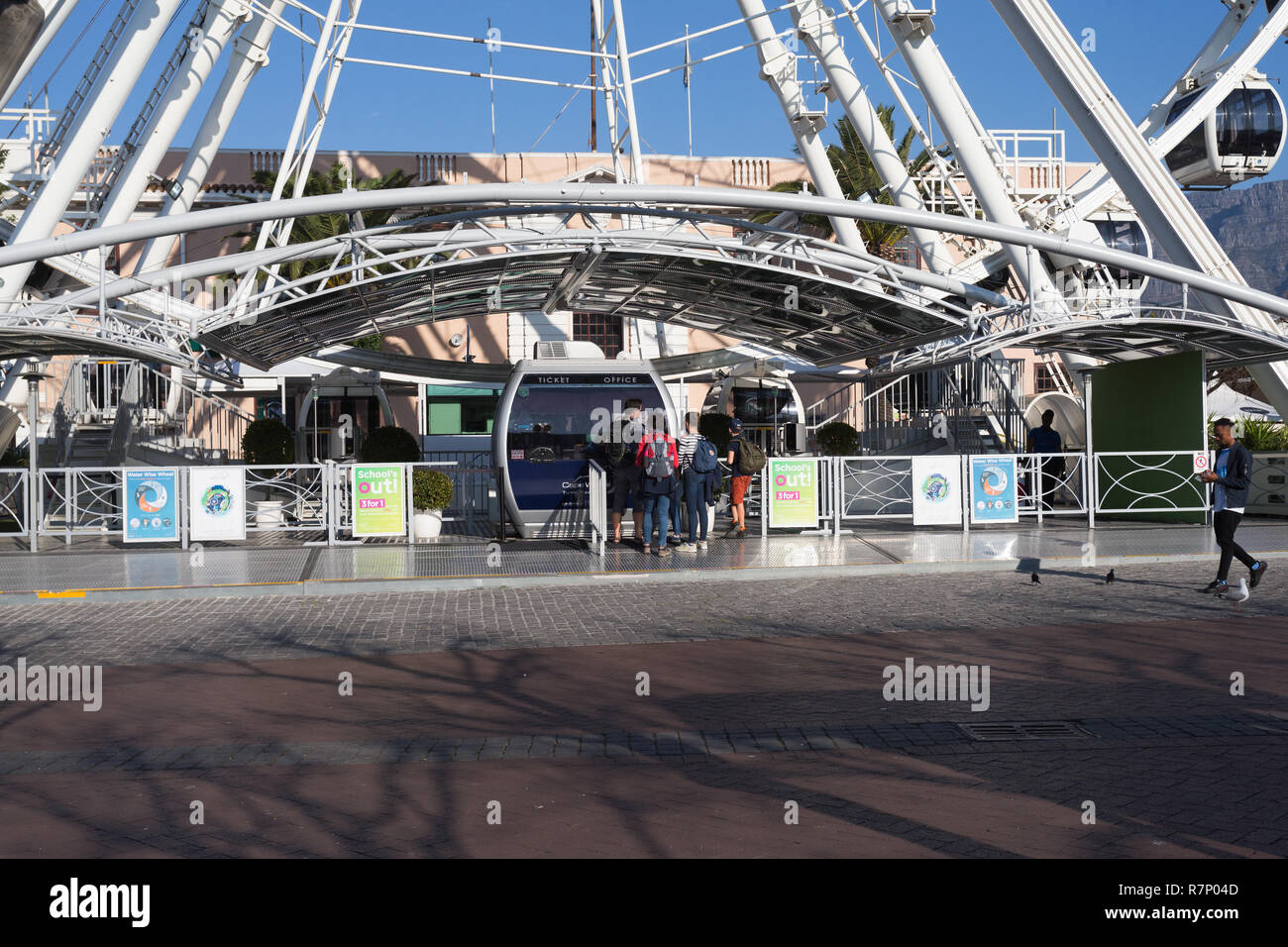 Capo ruota Ferris Wheel o grande ruota a V&A Waterfront di Città del Capo in Sud Africa con persone ad acquistare i biglietti presso la biglietteria o la biglietteria Foto Stock