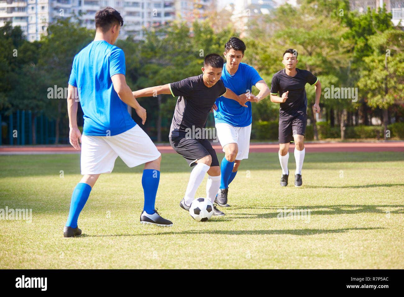 Un gruppo di giovani asiatici soccer football giocatore giocare sul tribunale aperto. Foto Stock