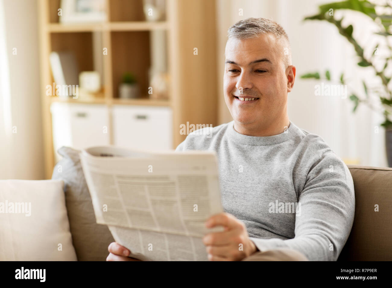 Uomo che legge il giornale a casa Foto Stock