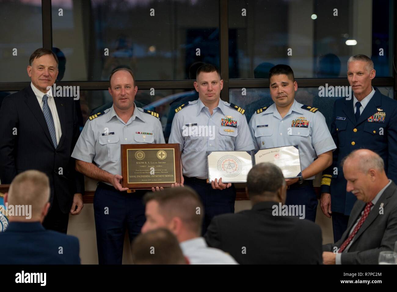 La guardia costiera della Cmdr. Jon Baker, Lt. La Cmdr. Brook Sherman, e il tenente Raymond Pamatian, della Naval Engineering Department di Boston, accettare il 2016 Lucas - placca di terra award per il dipartimento di ingegneria della Guardia Costiera di Boston di base nel corso di una cerimonia presso la Guardia costiera in cantiere Baltimore, Md., Marzo 21, 2017. Il premio membri, in parte, che il team di 180 ingegneri navali di stanza in tutta la prima guardia costiera eseguito del distretto di 150.000 ore di produzione industriale non vale $6,7 milioni su frese, barche, ausili alla navigazione e la riva di strutture, compresi 27 un bacino di carenaggio e dock-lato availa manutenzione Foto Stock