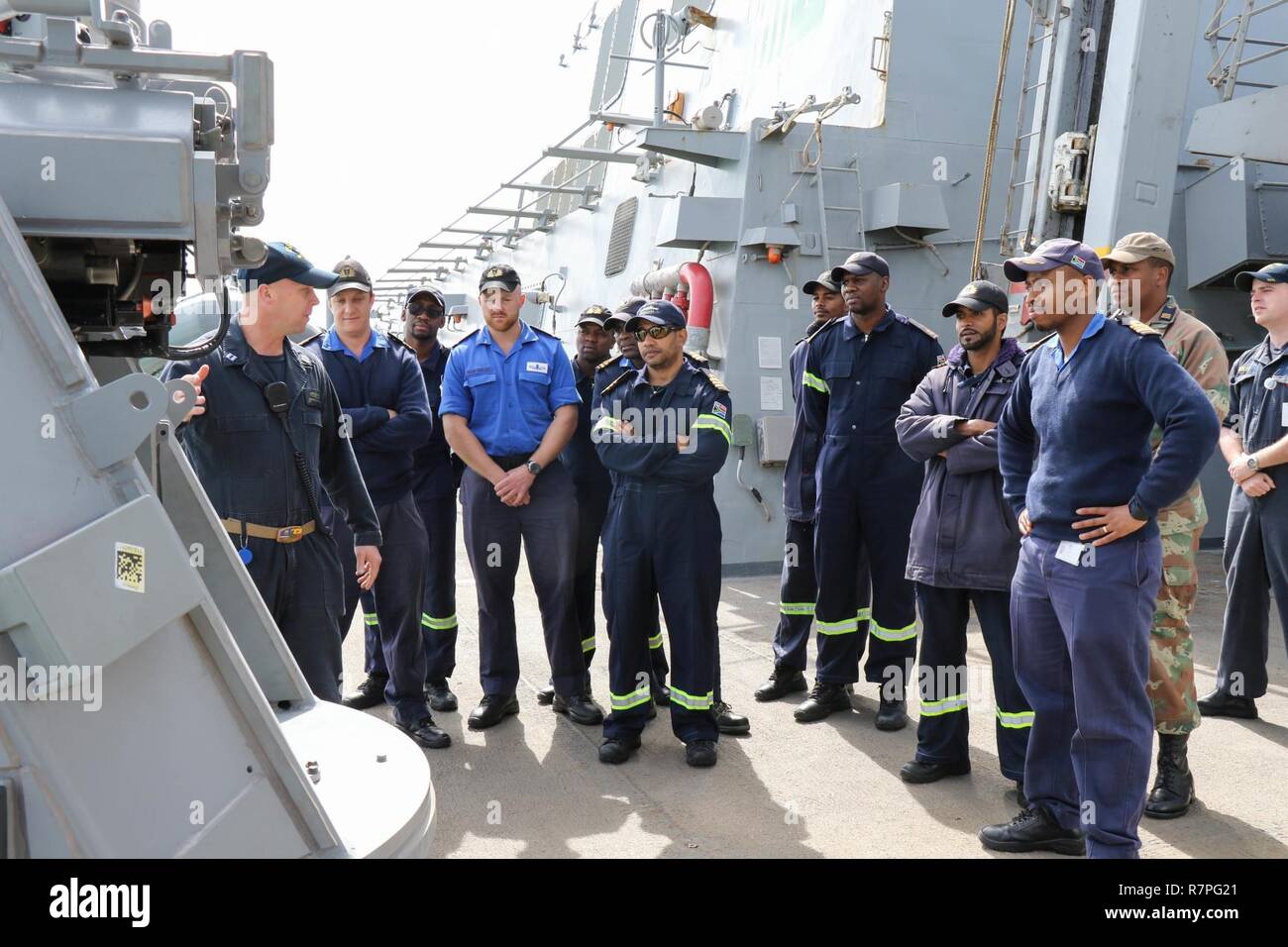 ROTA, Spagna (22 marzo 2017) Lt. Christian Seymour, a sinistra la Operations Officer a bordo del Arleigh Burke-class missile destroyer USS Ross (DDG 71), mostra South African velisti assegnati al SAS Amatola (F 145) recentemente installata Mark 38 25 mm mitragliatrice sistema. Ross è distribuita a Rota, Spagna conducendo operazioni navali negli Stati Uniti Sesta flotta area di operazioni a sostegno degli Stati Uniti per gli interessi di sicurezza nazionali in Europa e in Africa. Foto Stock