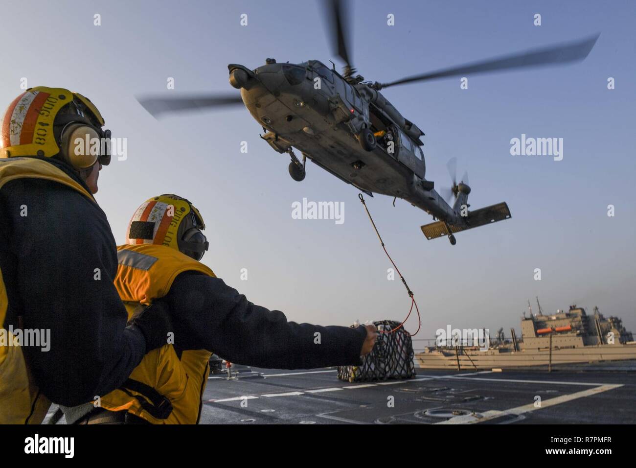 Stati Uniti 7TH FLOTTA AREA DI OPERAZIONI (27 marzo 2017) di Boatswain mate 1. Classe Runsiya Richards (anteriore) da Tacoma, Washington, e marinaio Thomas Bade, da San Luigi, Michigan, il segnale ad un MH-60S Sea Hawk elicottero, attaccato al mare in elicottero Combat Squadron (HSC) 4, che porta il carico da Lewis e Clark-secco classe nave cargo USNS Charles Drew (T-AKE 10) durante un rifornimento verticale in mare a bordo di Arleigh Burke-class guidato-missile destroyer USS Wayne E. Meyer (DDG 108). Wayne E. Meyer è su un regolarmente programmati Pacifico occidentale di implementazione con la Carl Vinson Carrier Strike gruppo come pa Foto Stock