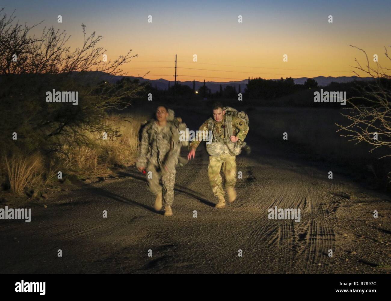 La riserva di esercito Sgt. Stephen Messenger (a destra), un information technology specialist assegnato al primo informazioni di comando operazioni, 335a comando di segnalazione (teatro) e la riserva di esercito di Spc. Julian Ditona, un multi-canale dei sistemi di trasmissione operatore/manutentore, assegnato per il novantottesimo segnale Expeditionary battaglione, 335sc (T) per correre il traguardo di un temporizzato 10-chilometro ruck marzo con 35-pound pack sulle loro spalle 30 Marzo come parte del comando's 2017 miglior guerriero che la concorrenza venga mantenuta a Fort Huachuca, Arizona. Foto Stock