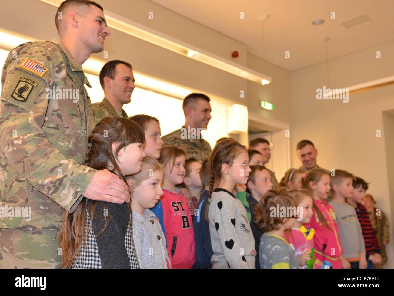 Cinque soldati della società b. (Barbaro), 1° Battaglione, sessantottesima Armor reggimento, 3° Brigata corazzate contro la squadra, 4a divisione di fanteria, Fort Carson, Colorado, posano per una foto con i bambini a Vytautus Kasiulis Art Museum di Vilnius, Lituania, Marzo 30. L evento è stato nello spirito di U.S. Esercito la partecipazione alla NATO e la dimostrazione di impegno per gli alleati non solo mediante la formazione con l'esercito lituano ma interagenti con membri della sua comunità. Da sinistra a destra: 1Lt. Justin Rogers, Battaglione Liaison Officer; Sgt. Garrett Langley, terzo plotone leader di squadra; 1Lt. Charles Gough, fanteria p Foto Stock