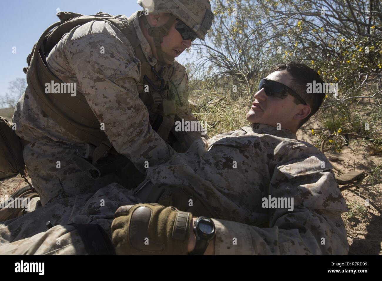 Stati Uniti Navy Hospital Corpsman Petty Officer classe terza Tyler P. Kelly, sinistra, con società di Echo, 2° Battaglione, 6° Reggimento Marine, seconda divisione Marine (2d MARDIV), conduce la simulazione di incidente di evacuazione procedure mediche durante il contro-improvvisato dispositivo esplosivo (C-IED) formazione in avanti su base operativa della Laguna, U.S. Army Yuma Proving Grounds per Taloni Esercizio (TalonEx) 2-17, Yuma, R.Z., 28 marzo 2017. Lo scopo di TalonEx era per la massa unità di combattimento di condurre la formazione integrata nel supporto di armi e tattiche corso istruttori (WTI) 2-17 ospitato da aviazione marino armi e TAC Foto Stock