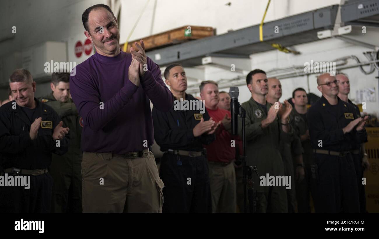 Sul mare del sud della Cina (1 aprile 2017) Il capitano Eric Anduze, il delegato della portaerei USS Carl Vinson (CVN 70), da manati, Puerto Rico, applaude durante un tutte le mani chiamata nell'hangar bay. La Carl Vinson Carrier Strike gruppo è su un regolarmente programmati Pacifico occidentale la distribuzione come parte degli Stati Uniti Flotta del pacifico-led iniziativa di estendere il comando e le funzioni di controllo di Stati Uniti 3a flotta. U.S Navy portaerei strike gruppi hanno pattugliato il Indo-Asia-Pacifico regolarmente e sistematicamente per più di 70 anni. Foto Stock