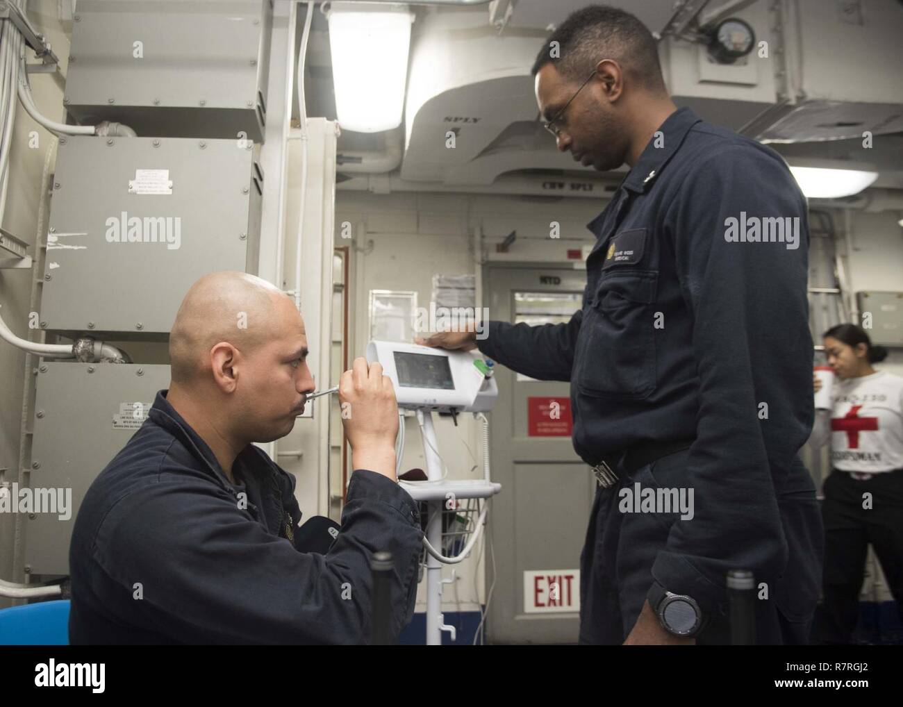 Oceano atlantico (1 aprile 2017) Ospedale Corpsman 3rd Class David Ross legge la temperatura di elettricista in Mate Fireman Hugo Lagraba in un medico di spazio a bordo della portaerei USS Dwight D. Eisenhower CVN (69) (IKE). Ike e la sua portante strike gruppo sono in corso condurre un esercizio di supporto a sostegno della flotta ottimizzato il piano di risposta (OFRP). Foto Stock