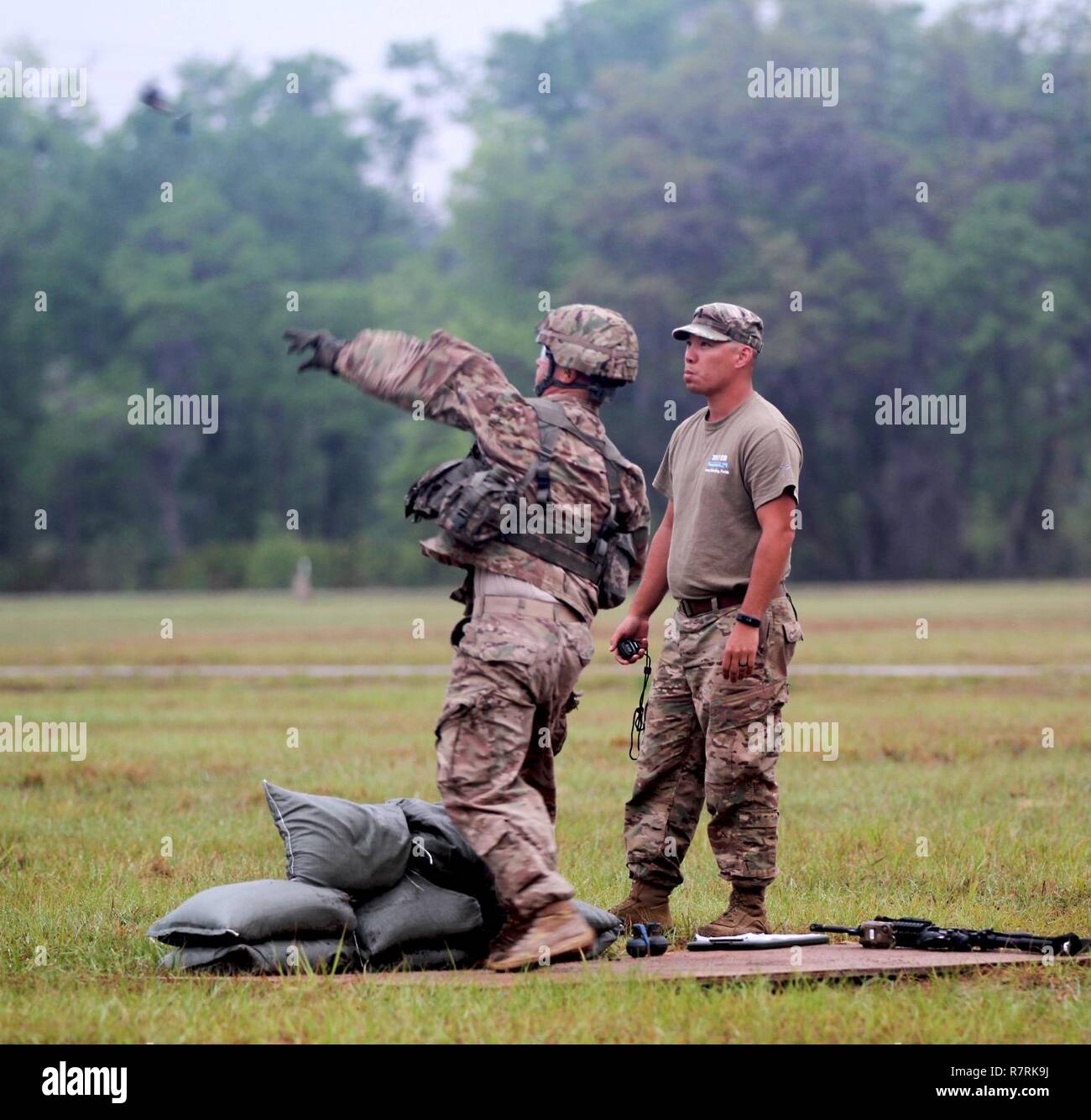 Un U.S. Esercito Nazionale soldato di guardia dal 2° Battaglione, 124Reggimento di Fanteria Lancia una granata durante l'esperto di fanteria qualifica di badge a Camp Blanding Training Center, Starke, Fla. il 5 aprile, 2017. Soldati sono stati contrassegnati sulla distanza, la precisione e la giusta forma. Dopo aver gettato due granate dalla posizione eretta, i soldati dovevano bassa crawl e gettare un altro granata in un bunker correttamente. Foto Stock