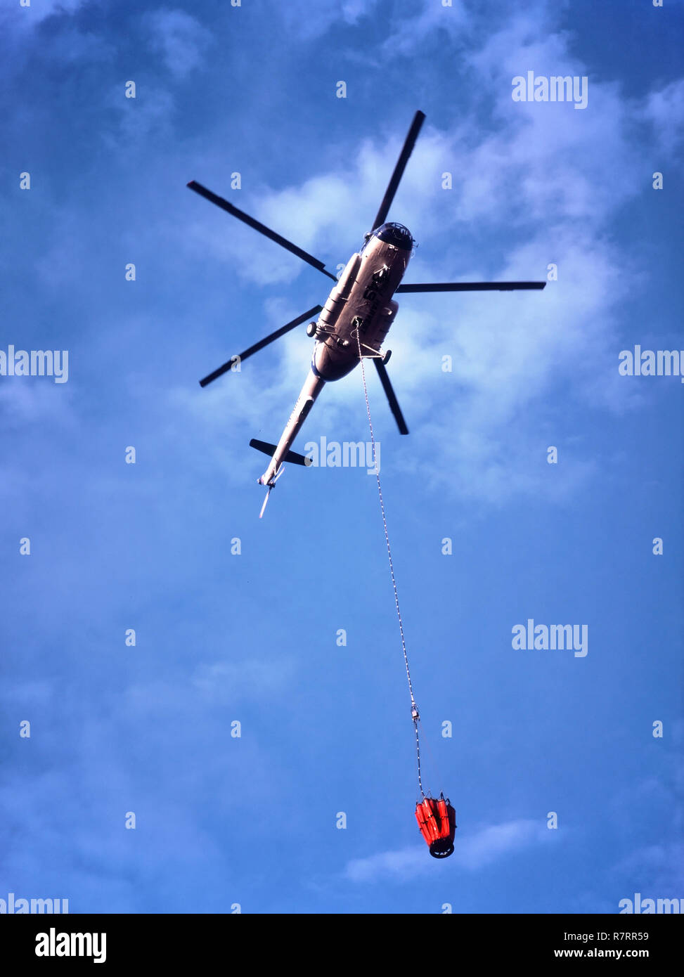 Fire Fighting elicottero, ER-MHZ Mil Mi-8MTV-1 il sollevamento pesante elicottero con acqua portando Bambi Bucket pendente da un 30 metri di lunghezza della linea. Foto Stock