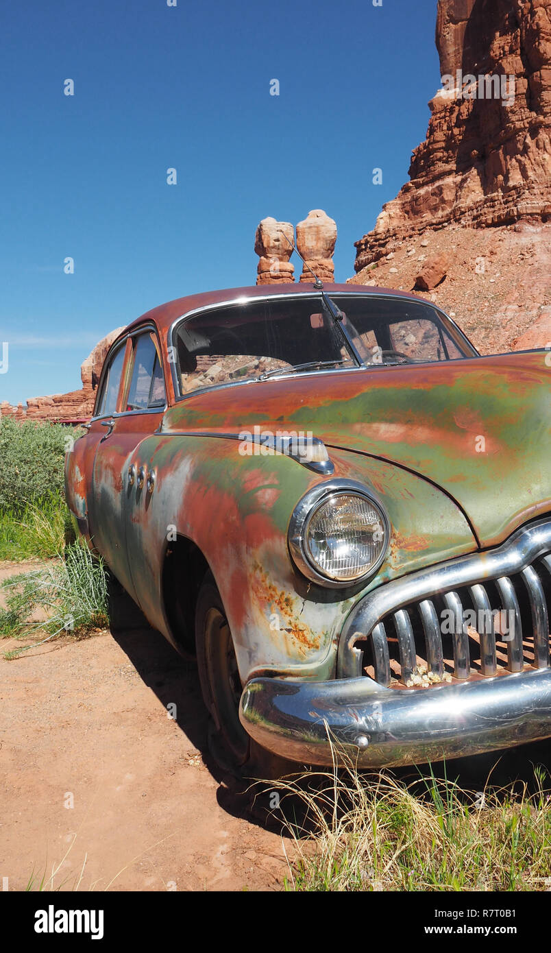 Rusty auto d'epoca, abbandonati nella sabbia di fronte al scogli gemelli di Bluff Foto Stock