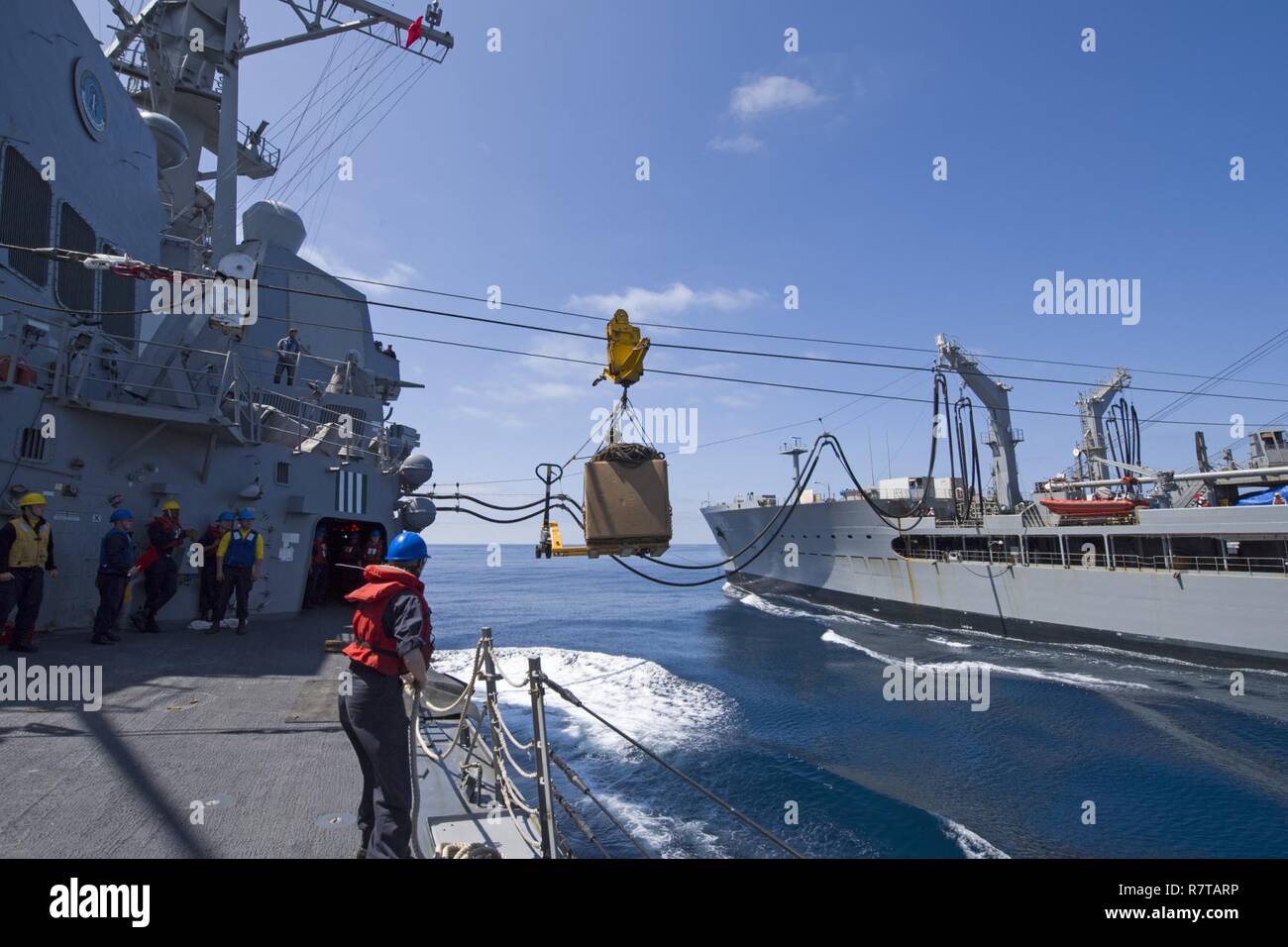 Oceano Pacifico (4 aprile 2017) marinai a bordo Arleigh Burke-class guidato-missile destroyer USS Sterett (DDG 104) invia un pallet di Henry J. Kaiser-class flotta oliatore di rifornimento USNS Yukon (T-AO-202) durante un rifornimento in corso. Sterett è parte della superficie Sterett-Dewey Action Group ed è il terzo gruppo di distribuzione che operano sotto il comando ed il controllo costrutto denominato 3a flotta in avanti. Stati Uniti 3a flotta operante in avanti offre opzioni aggiuntive per la flotta del Pacifico commander sfruttando le capacità del 3° e 7° flotte. Foto Stock