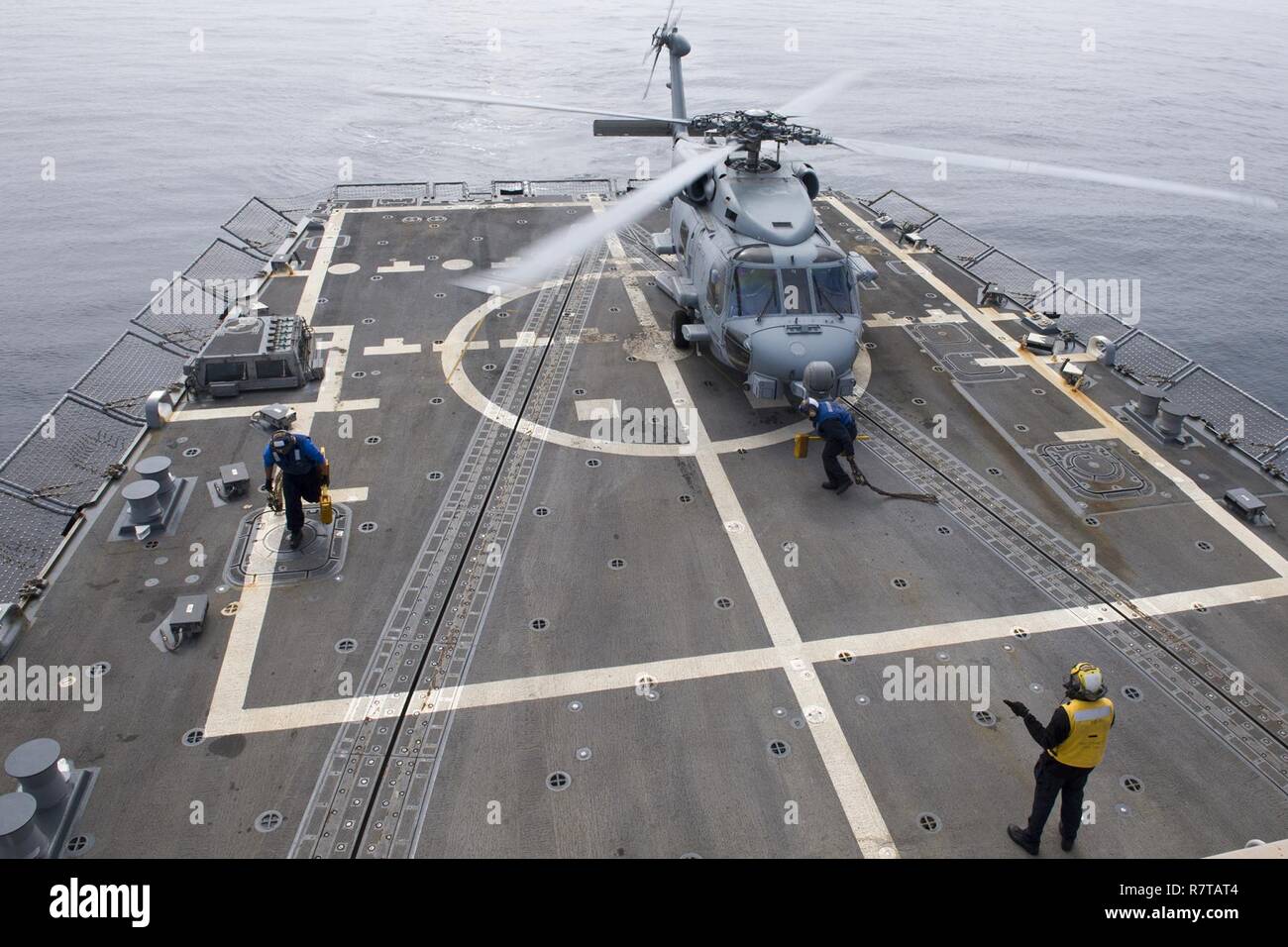 Oceano Pacifico (5 aprile 2017) velisti assegnati al Arleigh Burke-class guidato-missile destroyer USS Sterett (DDG 104) Rimuovere tacchi e catene da un MH-60R Sea Hawk elicottero assegnato all'elicottero Maritime Strike Squadron (HSM) 49. La nave è parte della superficie Sterett-Dewey Action Group, operanti sotto il comando ed il controllo costrutto denominato 3a flotta in avanti. Foto Stock