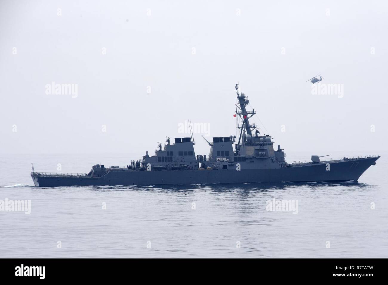 Oceano Pacifico (5 aprile 2017) un MH-60R Sea Hawk elicottero assegnato all'elicottero Maritime Strike Squadron (HSM) 49 vola sopra la Arleigh Burke-class guidato-missile destroyer USS O'Kane (DDG 77). Foto Stock