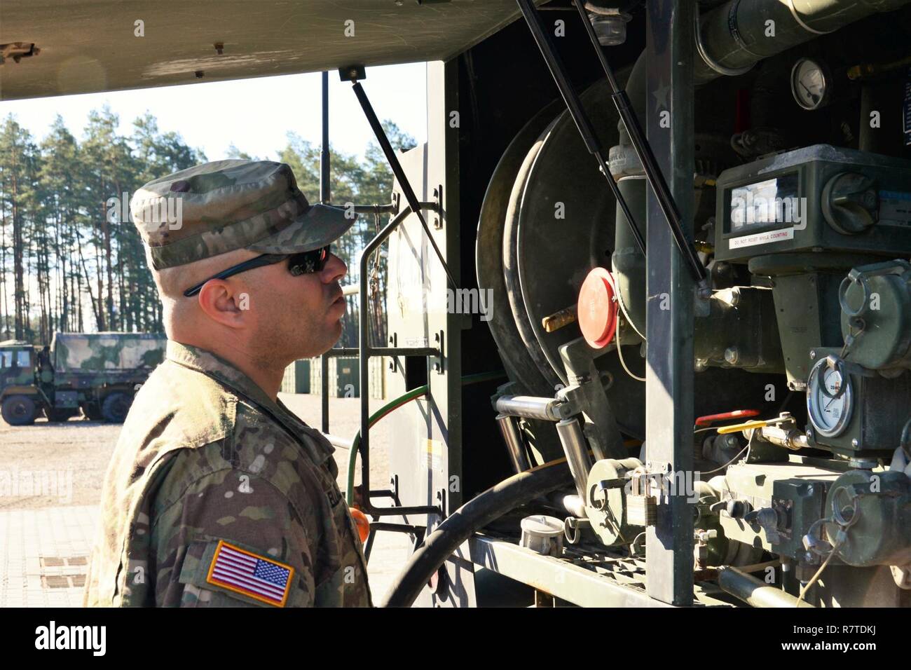 Soldati dal gruppo di combattimento della Polonia, rifornimento di carburante veicoli militari su Aprile 7, 2017 in Orzysz, Polonia. Gruppo di combattimento della Polonia, composta di Stati Uniti, Regno Unito Il rumeno e soldati polacchi, è attualmente implementato per Orzysz, in Polonia per un periodo di sei mesi a sostegno della NATO in avanti rafforzata presenza (eFP). NATO di Pfl è un allied, distribuito per la difesa e la dissuasione postura in Europa orientale per proteggere e rassicurare della NATO di Stati membri dell'Est della loro sicurezza. Foto Stock