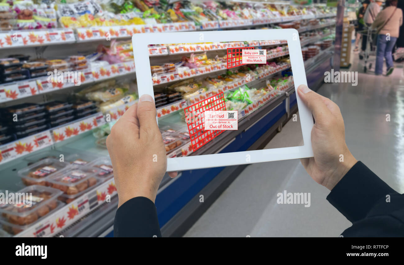 Iot smart retail nel futuristico concetto, il dettagliante tenere il tablet e utilizzare la realtà aumentata technology monitor dati di fuori di accantonare, prezzo, pl Foto Stock