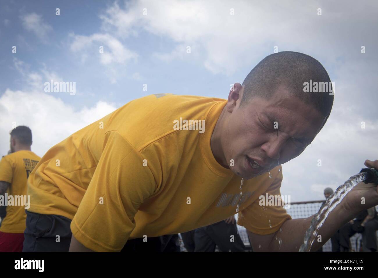 Sul mare del sud della Cina (8 aprile 2017) specialista culinaria di prima classe Wilson Ebreo, destra, decontamina dopo esposizione a Oleoresin Capsicum durante la sicurezza le forze reazionarie della formazione a bordo del Arleigh Burke-class guidato-missile destroyer USS Stethem (DDG 63). Stethem è di pattuglia nel Mare della Cina del Sud il supporto di sicurezza e stabilità nella Indo-Asia-regione del Pacifico. Foto Stock