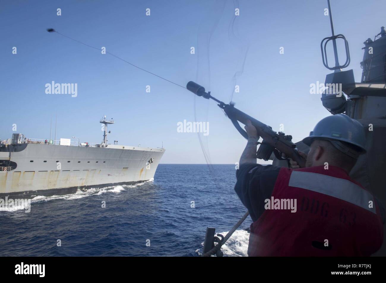 Sul mare del sud della Cina (8 aprile 2017) Fire Controlman 2a classe Kameron Huit, assegnato all'Arleigh Burke-class guidato-missile destroyer USS Stethem (DDG 63), spara un colpo la linea da un M14 fucile di servizio durante un in corso-rifornimento con USNS Pecos (T-AO 197). Stethem è di pattuglia nel Mare della Cina del Sud il supporto di sicurezza e stabilità nella Indo-Asia-regione del Pacifico. Foto Stock