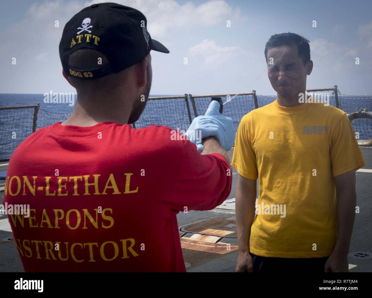 Sul mare del sud della Cina (8 aprile 2017) Gunners mate 1. Classe Michael Perry, sinistra, spray specialista della logistica 2a classe Wubin Liao, destro con Oleoresin Capsicum spray durante la sicurezza le forze reazionarie della formazione a bordo del Arleigh Burke-class guidato-missile destroyer USS Stethem (DDG 63). Stethem è di pattuglia nel Mare della Cina del Sud il supporto di sicurezza e stabilità nella Indo-Asia-regione del Pacifico. Foto Stock