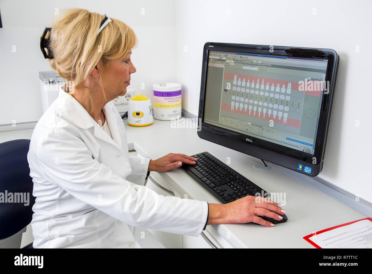 Assistente dentale immettendo i dati di un paziente nel record medici elettronici, Germania Foto Stock