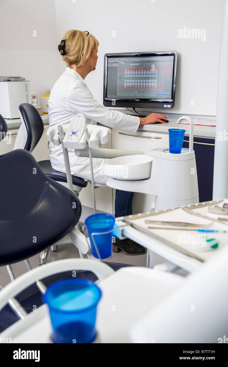 Assistente dentale immettendo i dati di un paziente nel record medici elettronici, Germania Foto Stock