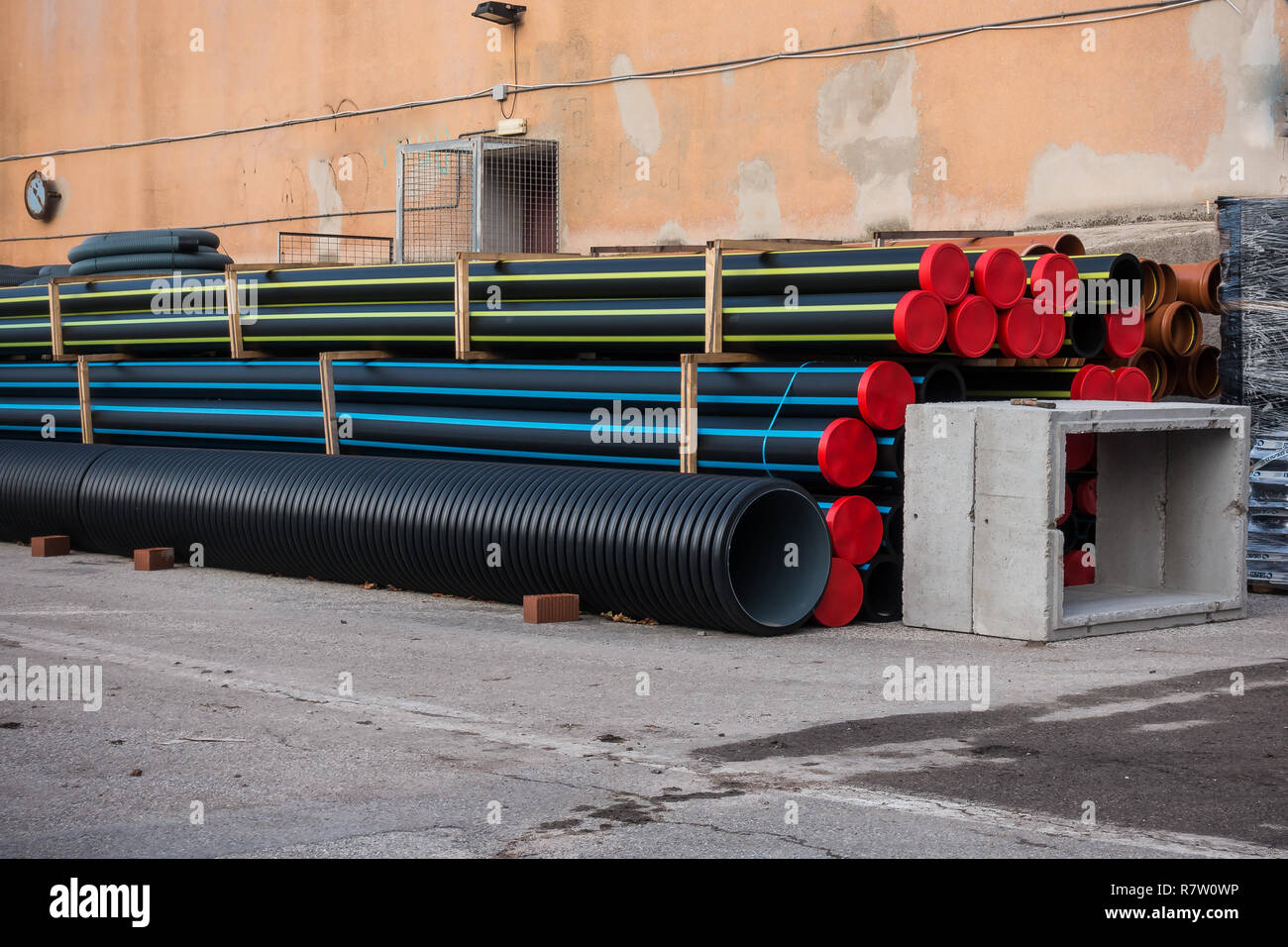 Pila di tubi in materia plastica e pozzetti prefabbricati per lavori stradali. Foto Stock