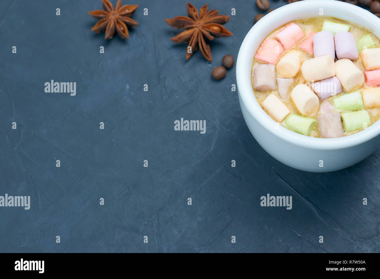 Bere caffè con marshmallows e spezie. su uno sfondo scuro. vista da sopra. copia di spazio. Foto Stock