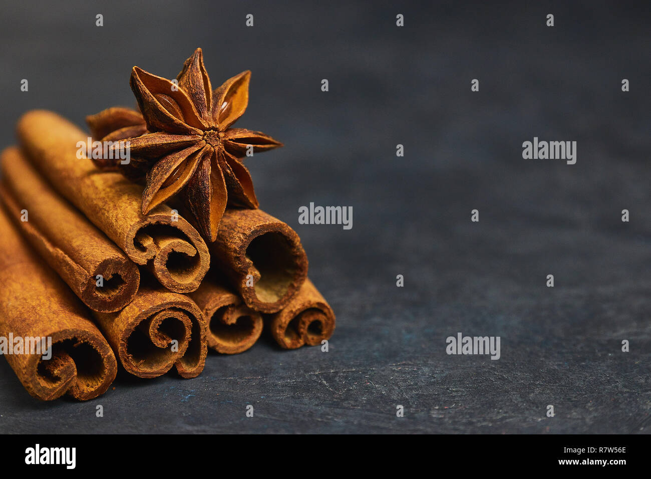 Bastoncini di cannella e cardamomo su uno sfondo nero vista orizzontale close-up con copia spazio per il testo Foto Stock