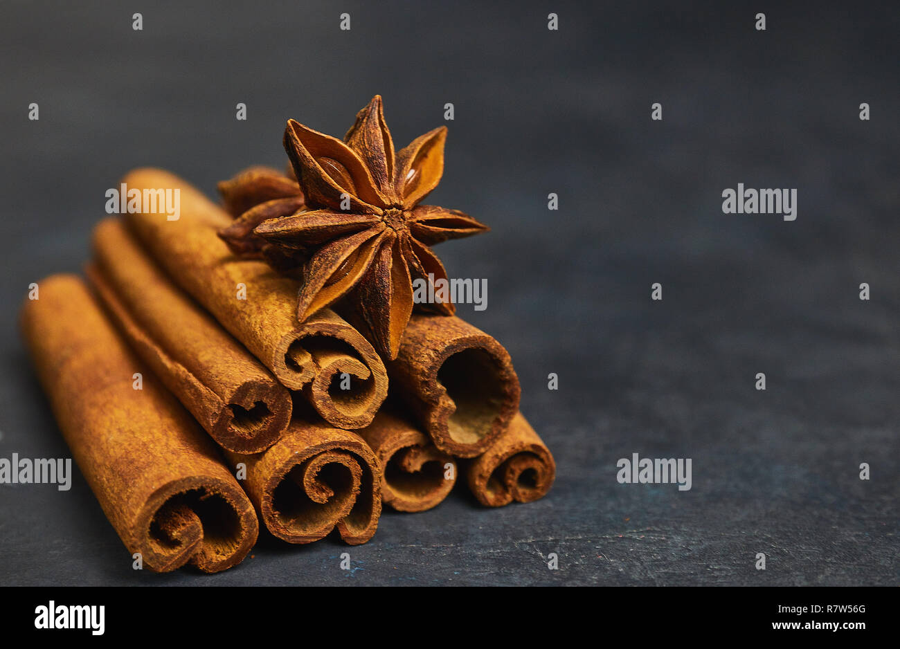 Bastoncini di cannella e cardamomo su uno sfondo nero vista orizzontale close-up con copia spazio per il testo Foto Stock