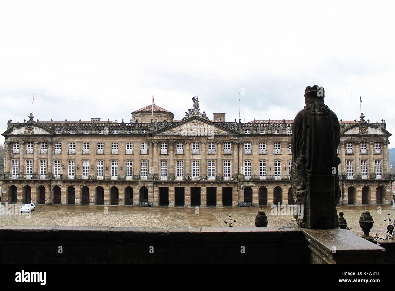 Facciata e cortile interno di un vecchio edificio europeo con il retro di una statua medievale in primo piano Foto Stock