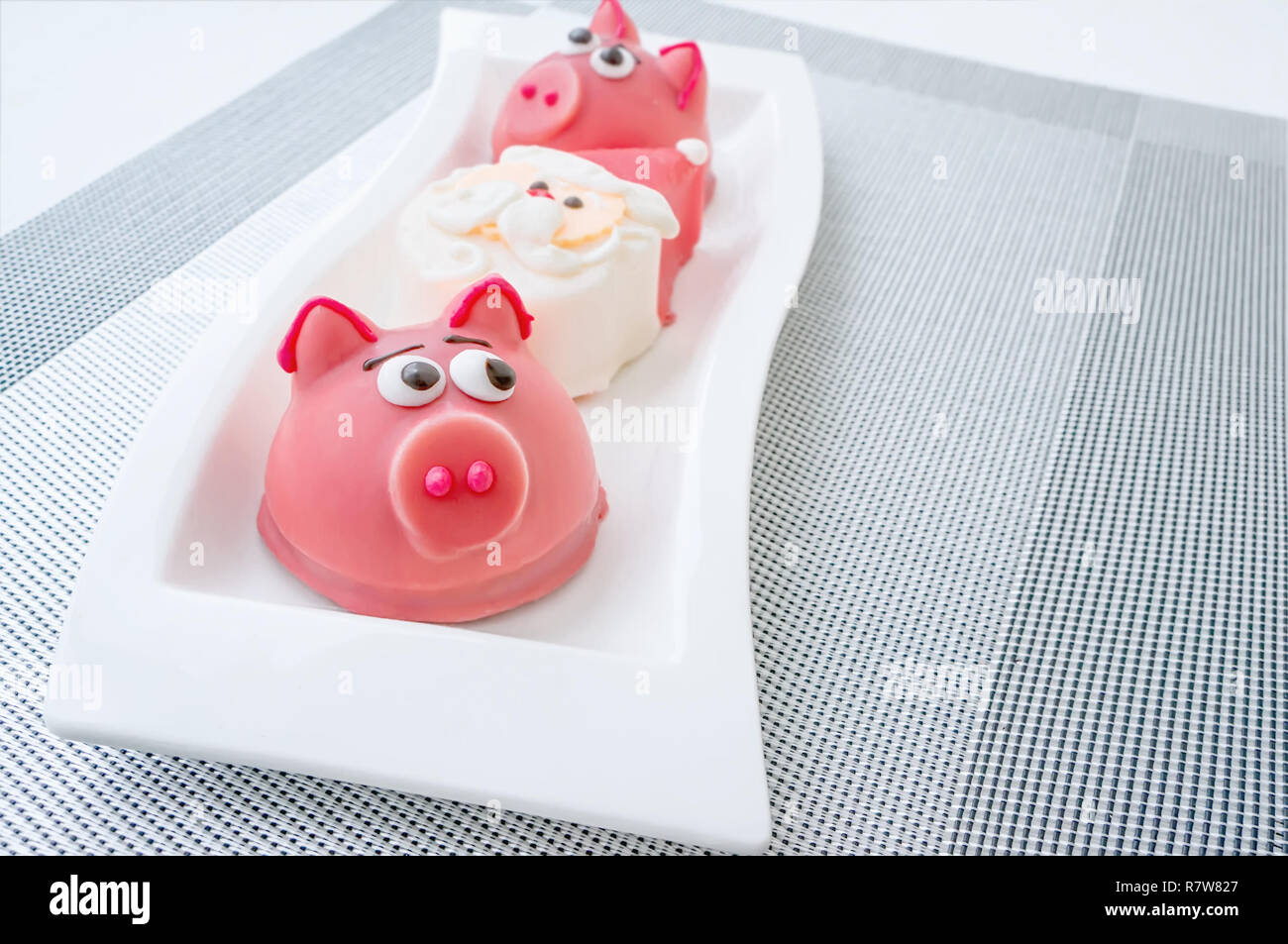 Il marzapane a forma del simbolo del nuovo anno rosa - maiale, dolce e delicato amaretti, marshmallows, arachidi zucchero in colori pastello su una luce posteriore Foto Stock
