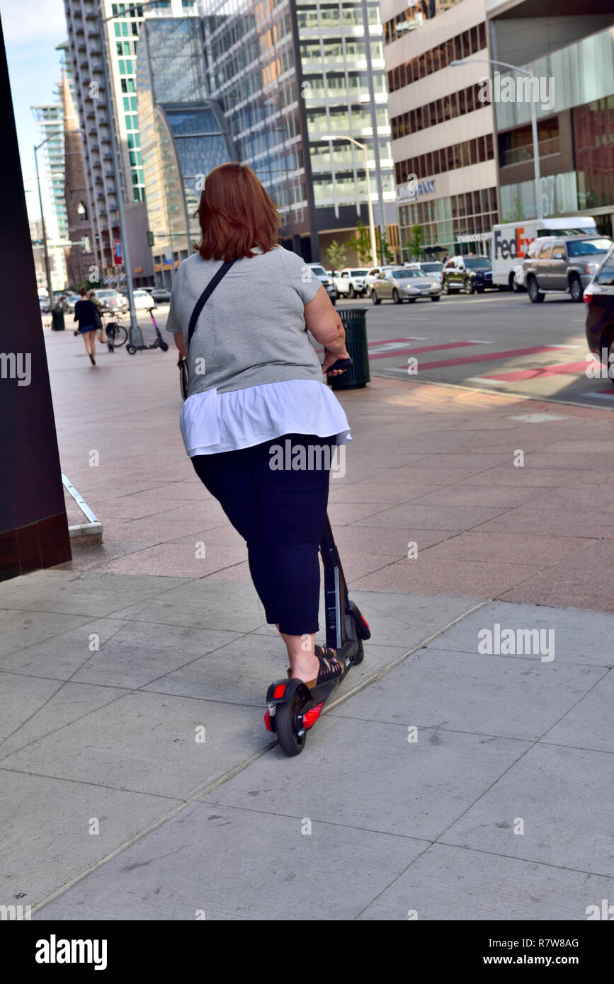 Donna su Bird dockless noleggio scooter elettrici a Denver, Colorado, STATI UNITI D'AMERICA Foto Stock