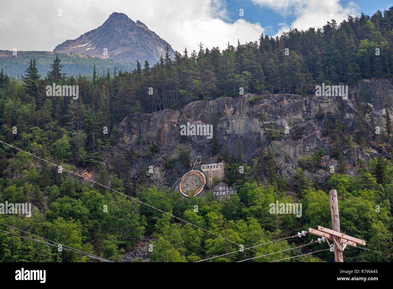 Kirmse la curiosità è un Skagway icona, il logo è dipinto sul lato della scogliera sopra la città, Skagway, Alaska, Klondike Gold Rush National Historical Park, STATI UNITI D'AMERICA Foto Stock