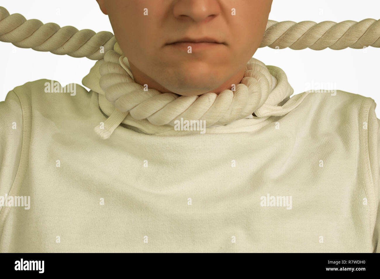 Un uomo con un loop da una corda intorno al suo collo in un maglione bianco su bianco sfondo isolato Foto Stock