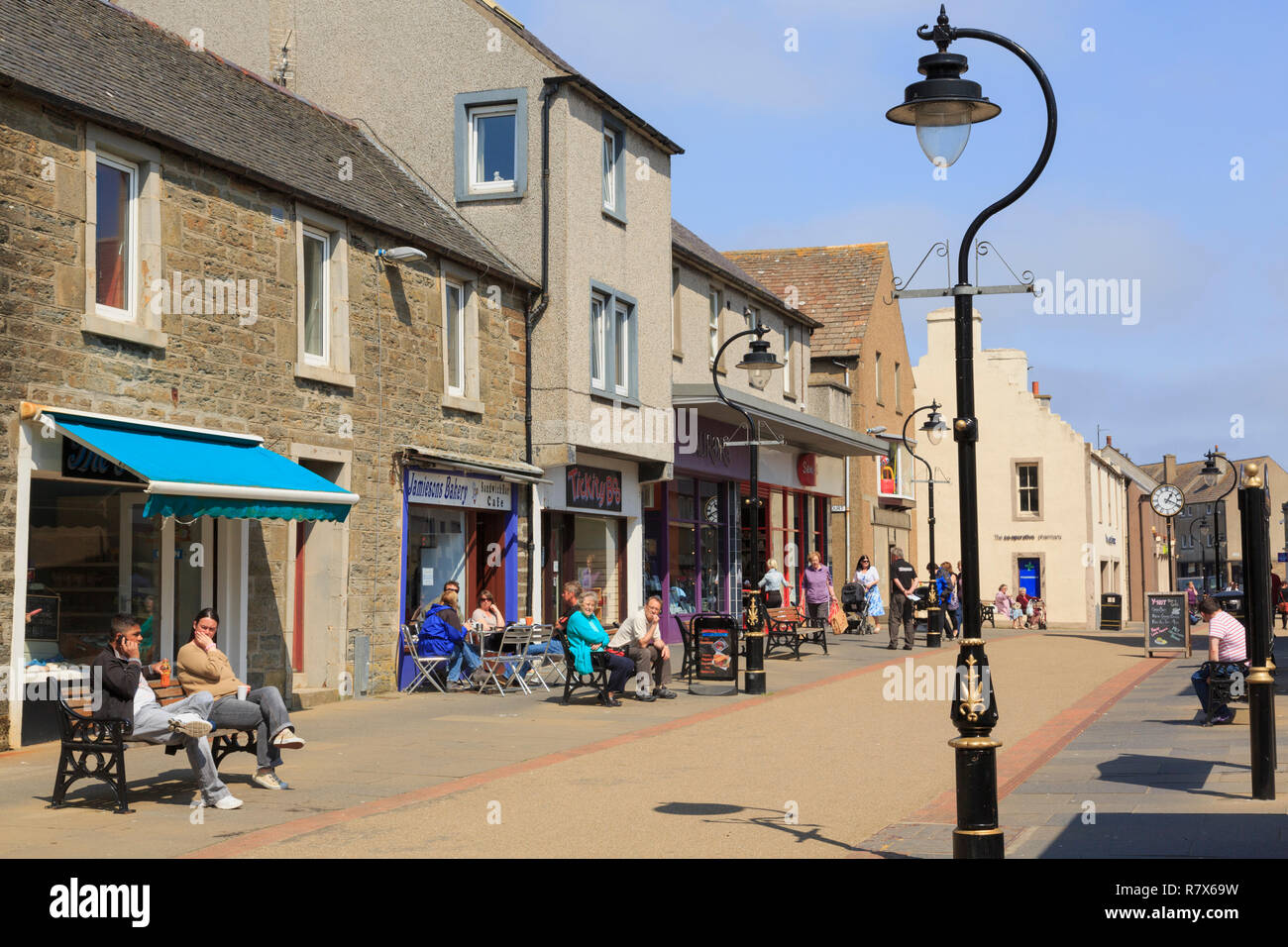 Scena di strada con negozi e persone nel centro della citta'. High Street, Thurso, Caithness in Scozia, Regno Unito, Gran Bretagna Foto Stock