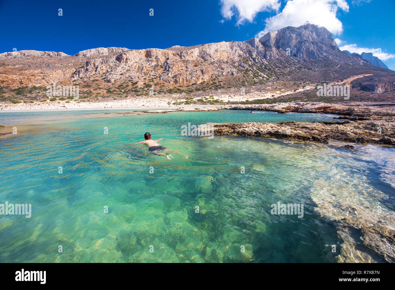 Giovane uomo attraente nuotare nella laguna di Balos sull isola di Creta con azure acqua chiara, la Grecia, l'Europa. Creta è la più grande e la più popolosa del GR Foto Stock