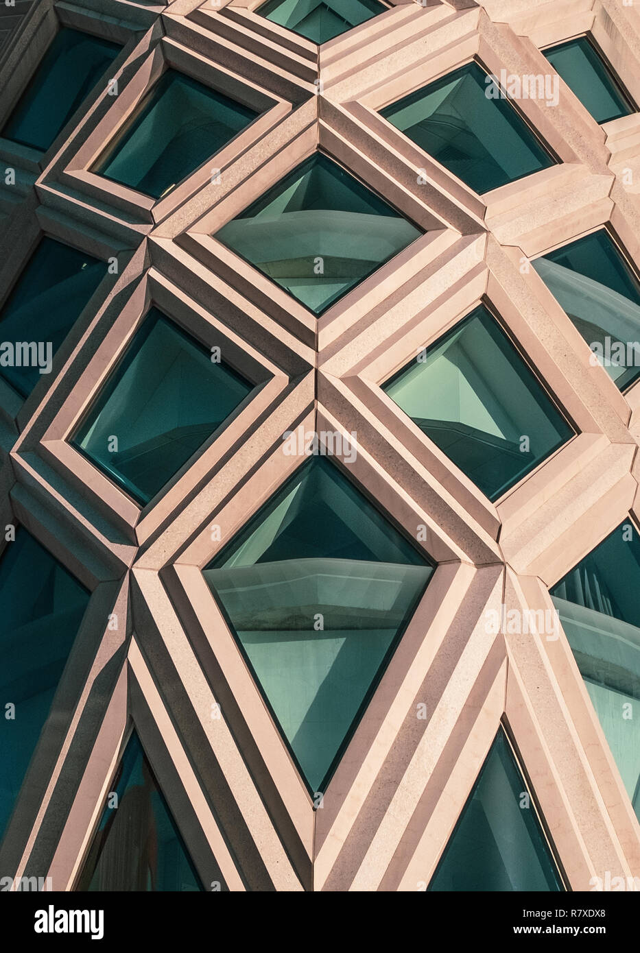Edificio con una facciata Diagrid. Inciso facciata di calcestruzzo. Edificio di roccia bianca. Greem Windows. Rombi. Forma triangolare. Foto Stock
