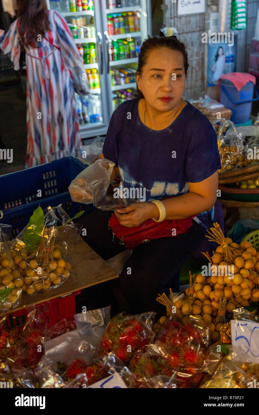 Le donne che vendono alimenti presso il mercato del treno a Bangkok, molto turistica sui mercati in cui il mezzo passa tra i negozi Foto Stock