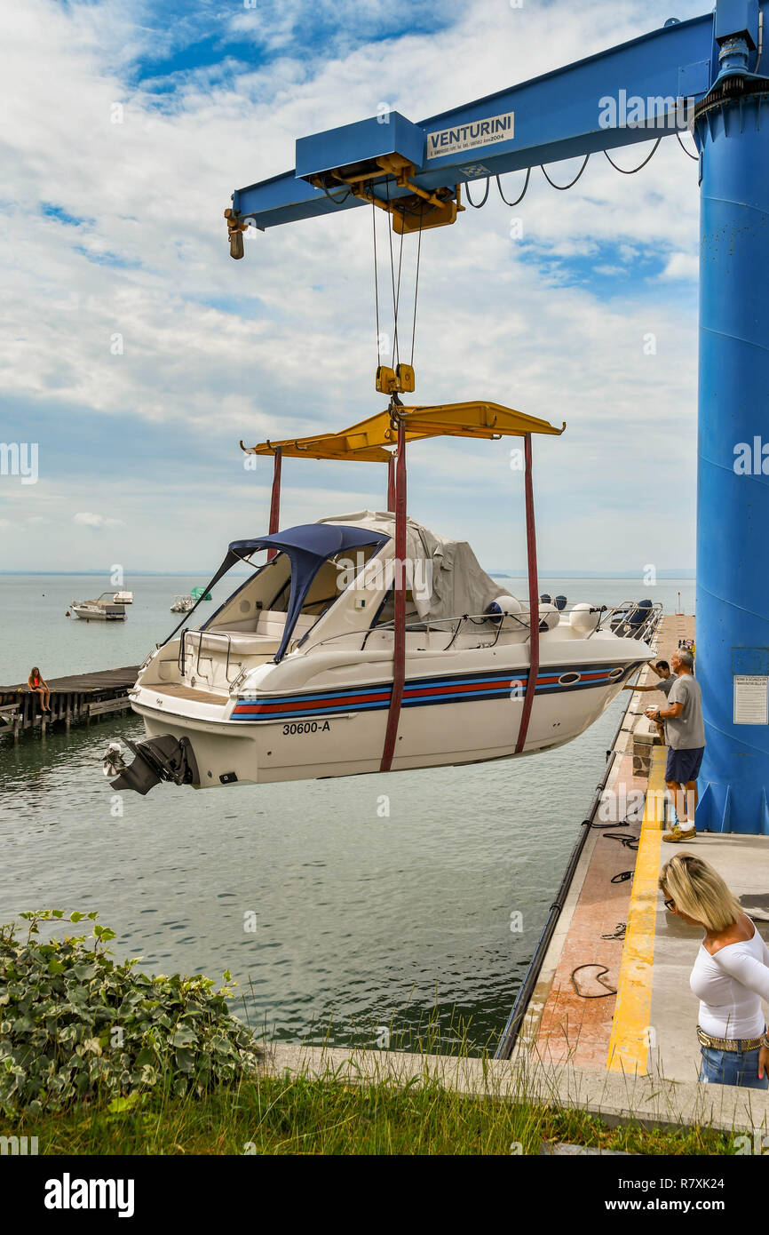 BARDOLINO, LAGO DI GARDA, Italia - Settembre 2018: gru di sollevamento un motore in acqua a un porto turistico sul Lago di Garda nei pressi di Bardolino. Foto Stock