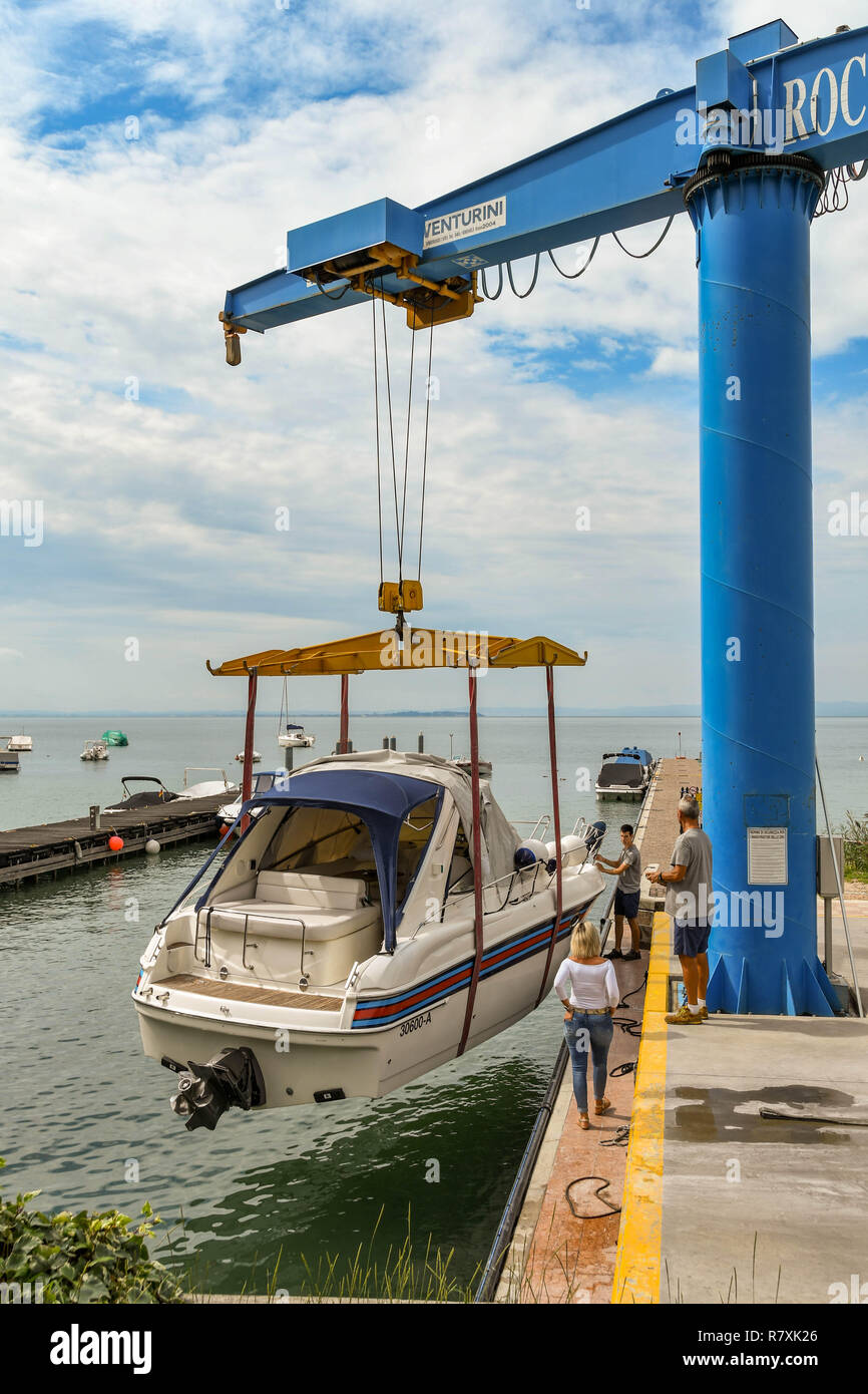 BARDOLINO, LAGO DI GARDA, Italia - Settembre 2018: abbassamento della gru un motore in acqua a un porto turistico sul Lago di Garda nei pressi di Bardolino. Foto Stock