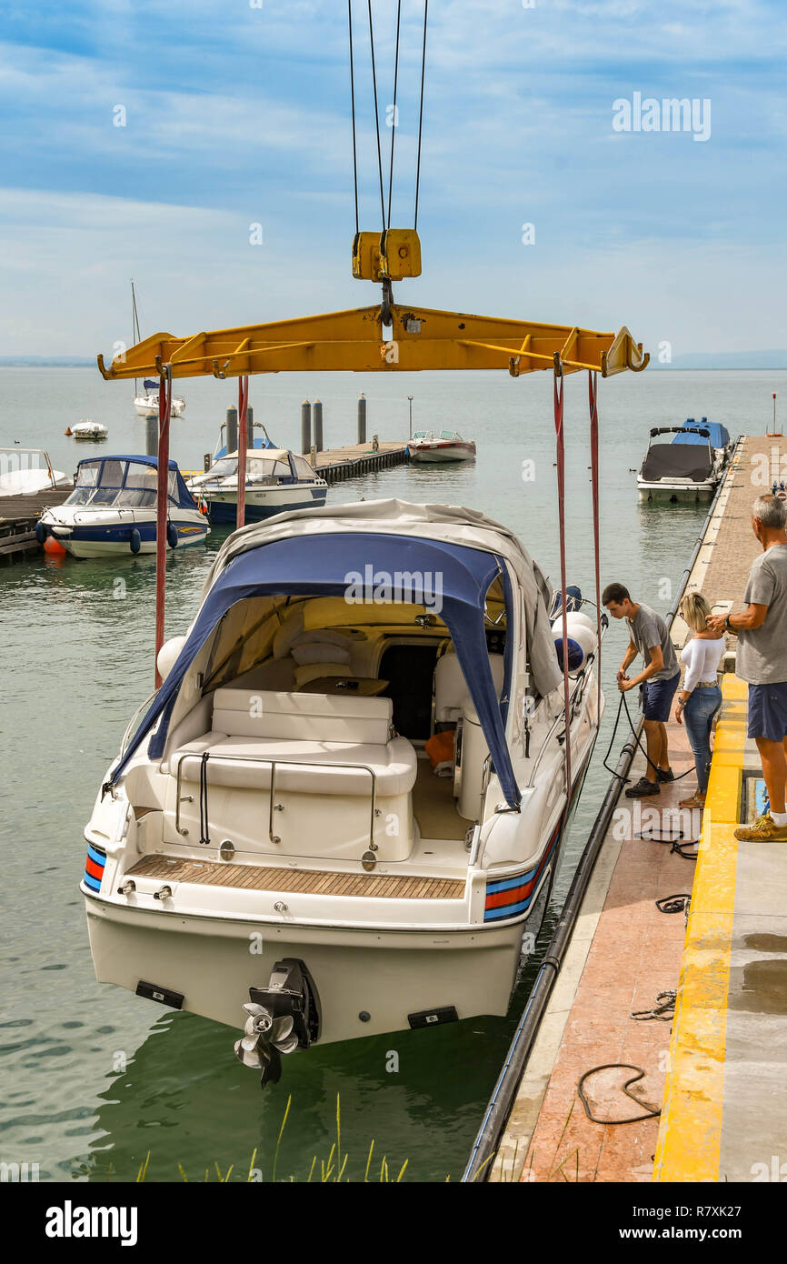 BARDOLINO, LAGO DI GARDA, Italia - Settembre 2018: abbassamento della gru un motore in acqua a un porto turistico sul Lago di Garda nei pressi di Bardolino. Foto Stock