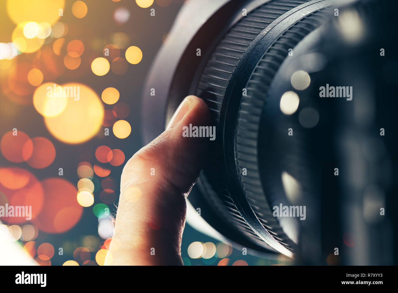 Fotografo con obiettivo zoom sulla fotocamera reflex digitale, close up del dito che ruotando l'anello sulle attrezzature fotografiche parte Foto Stock