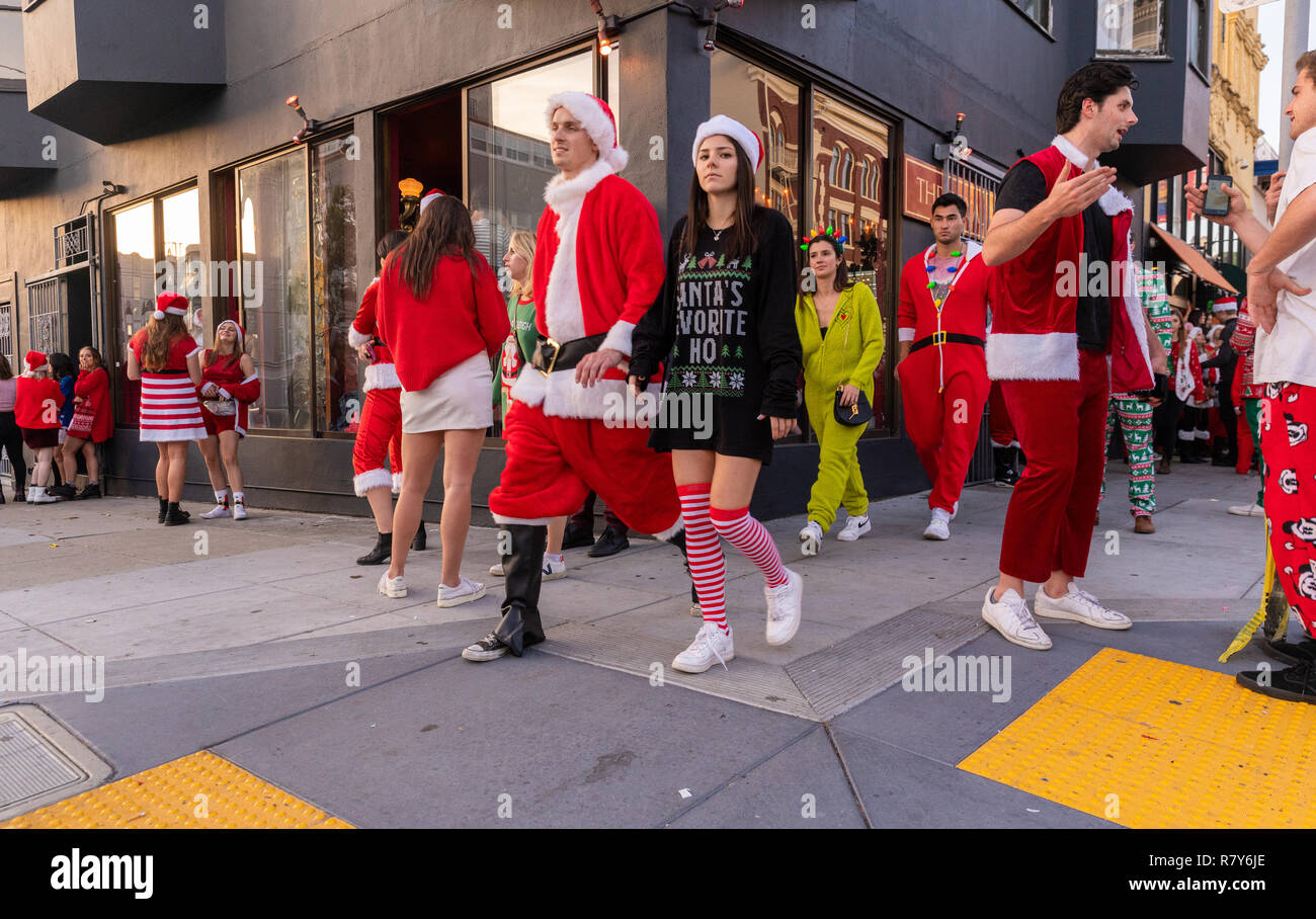 Holiday revelers in San Francisco vestito di Babbo Natale/Natale costumi per l annuale SantaCon pub crawl. Foto Stock