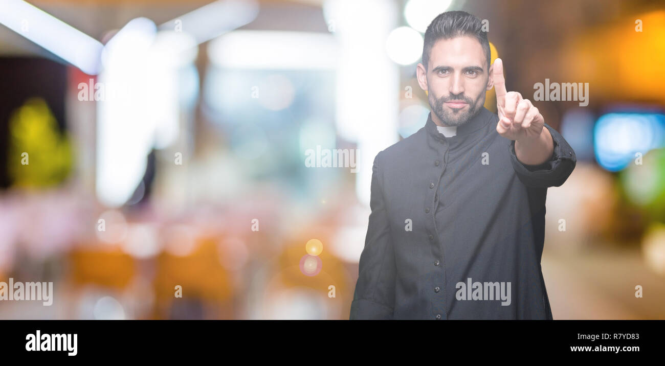 Bell'uomo prete ispanico con barba che tiene la bibbia e croce cristiana  scettica e nervosa, sconvolto a causa del problema. Persona negativa Foto  stock - Alamy