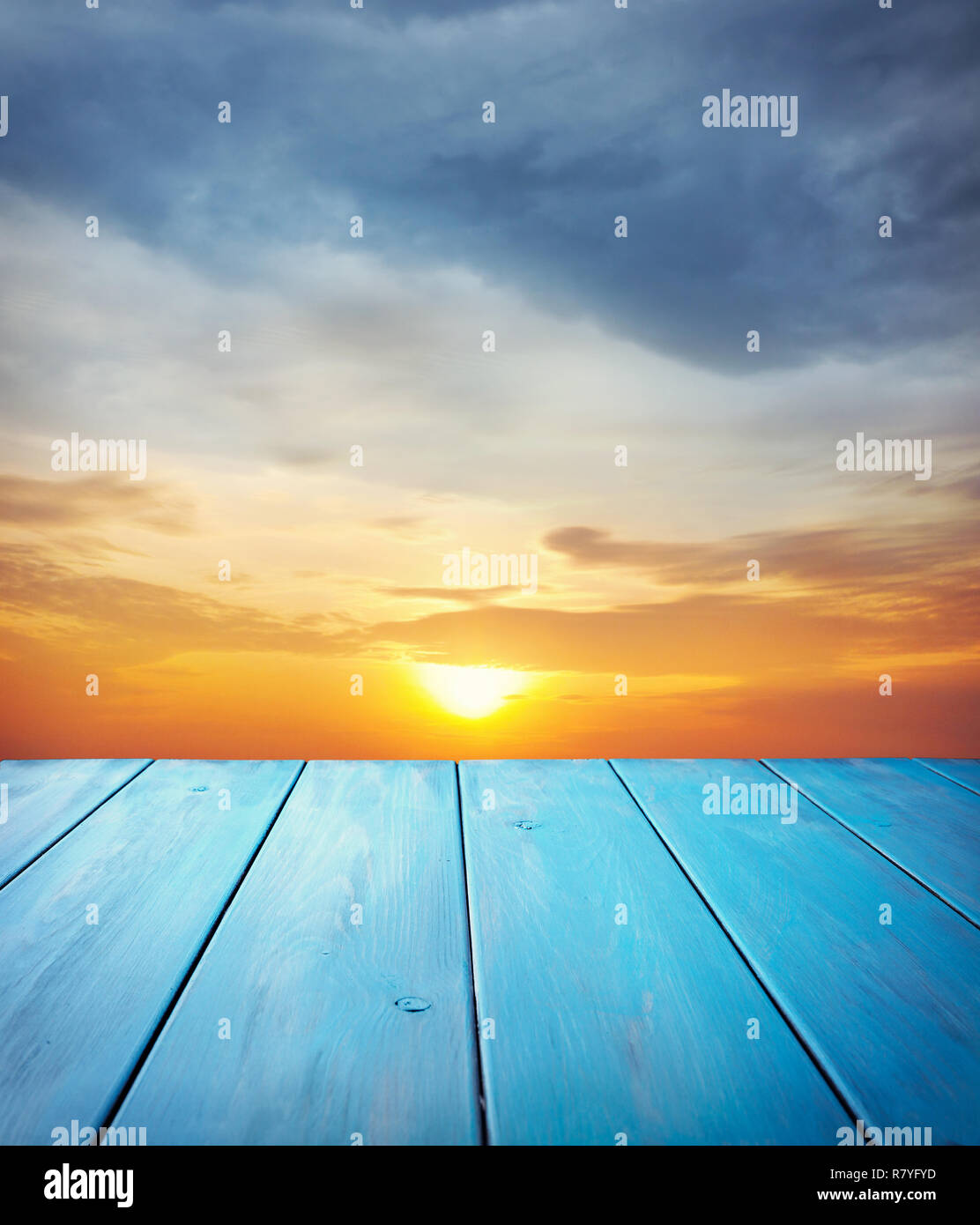 In legno di colore blu a tavola arancione tramonto sullo sfondo del cielo Foto Stock