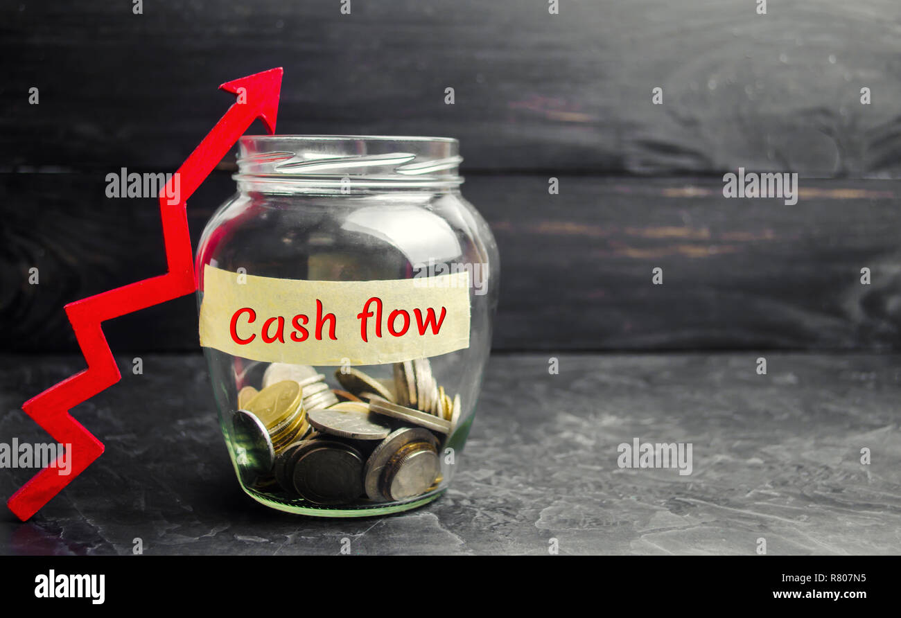 Vaso di vetro con monete e l'iscrizione ' flusso di cassa ' e la freccia verso l'alto. Piano finanziario. Gli investimenti e la crescita del patrimonio, piano di pensionamento, salari. Mone Foto Stock