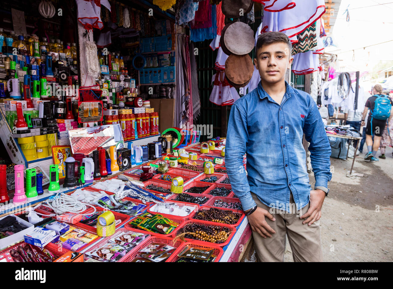 Khorog, Tagikistan 25 Agosto 2018: bel ragazzo è in piedi di fronte al suo stallo, in attesa di acquirente della sua mercanzia, Khorog, Tagikistan Foto Stock