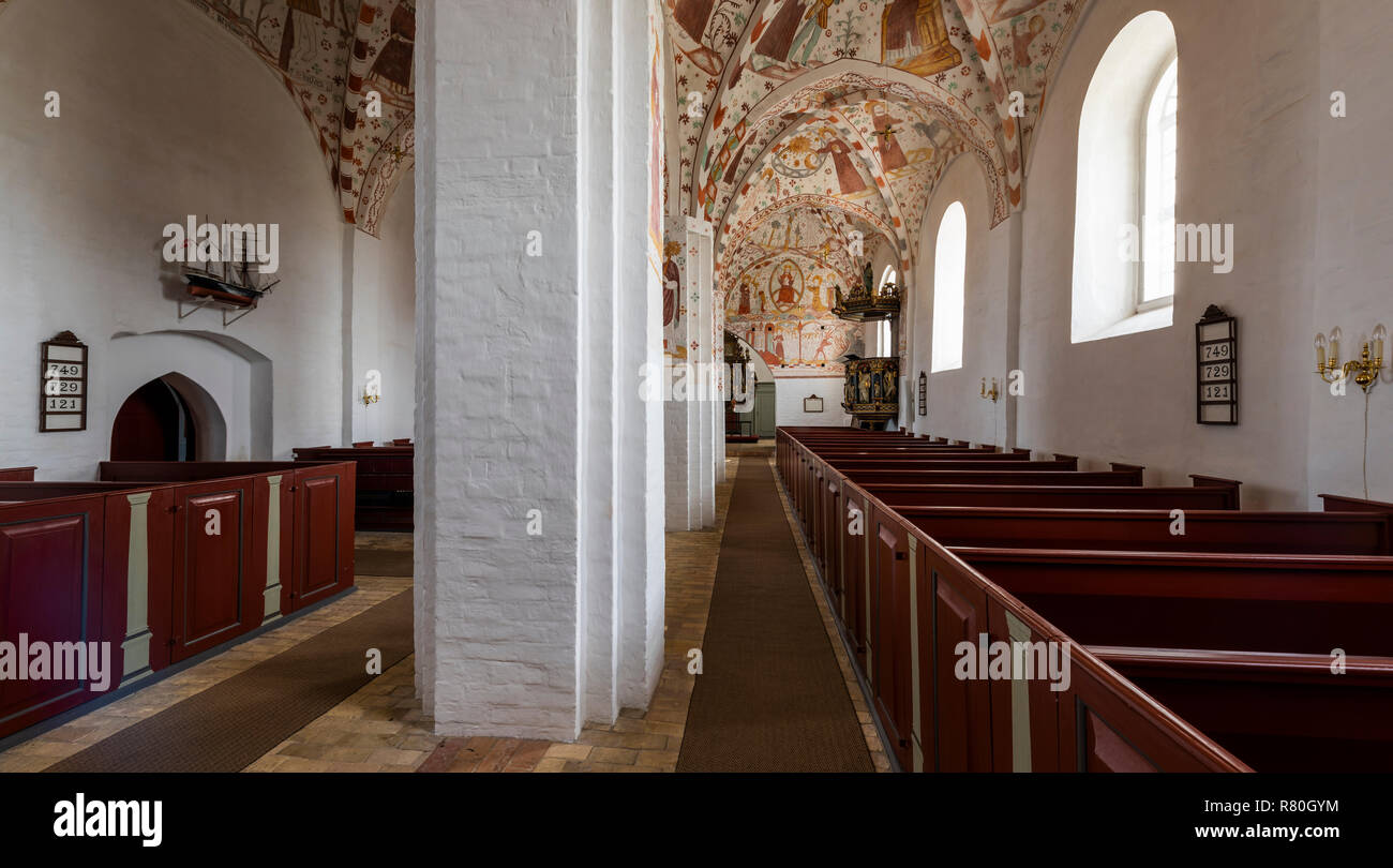 Mon, Danimarca - 17 Settembre 2018: Interno della chiesa Fanefjord con colorati soffitto dipinti di rosso e panchine di legno. Foto Stock