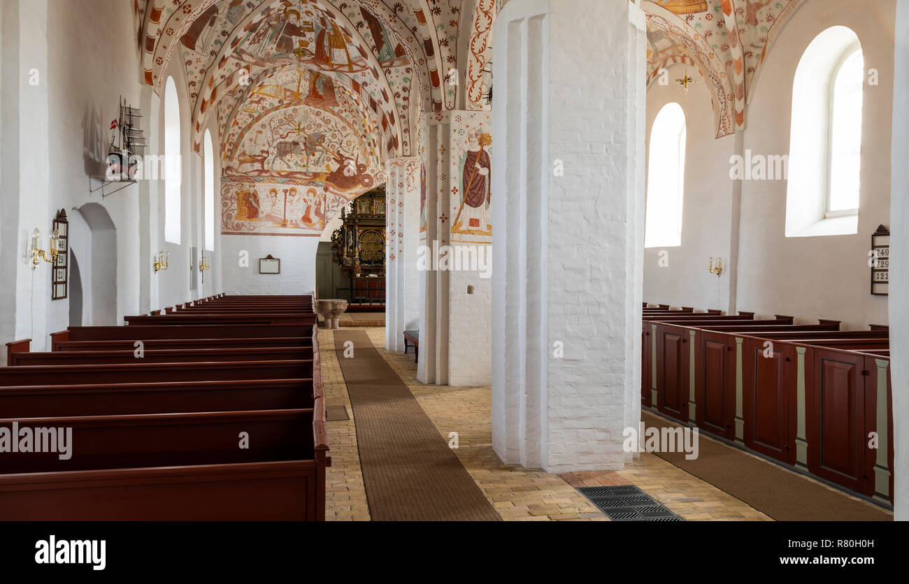 Mon, Danimarca - 17 Settembre 2018: Interno della chiesa Fanefjord con colorati soffitto dipinti di rosso e panchine di legno. Foto Stock