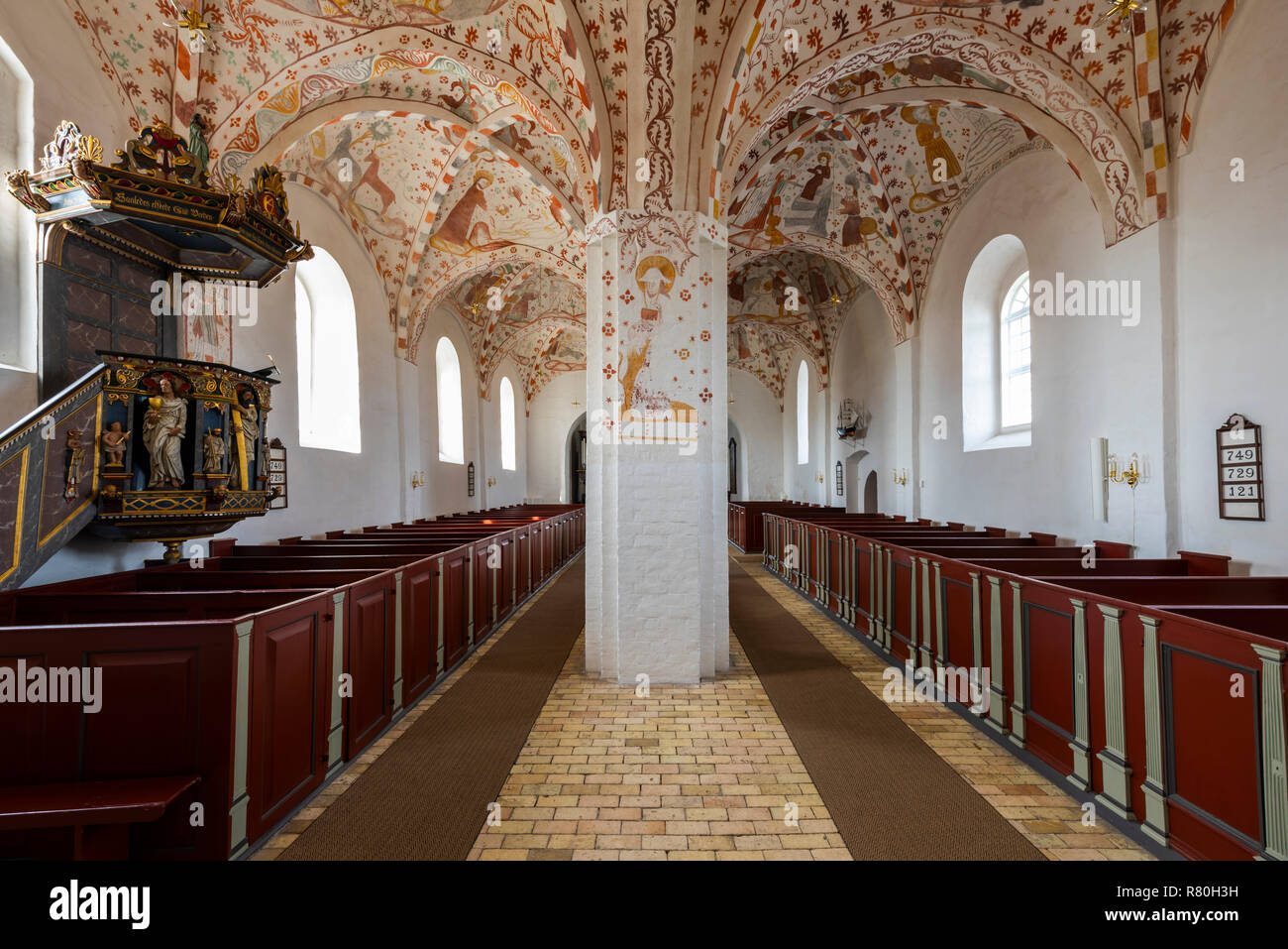 Mon, Danimarca - 17 Settembre 2018: Interno della chiesa Fanefjord con colorati soffitti con affreschi, un pulpitt dal 1645 e rosso, panchine di legno. Foto Stock